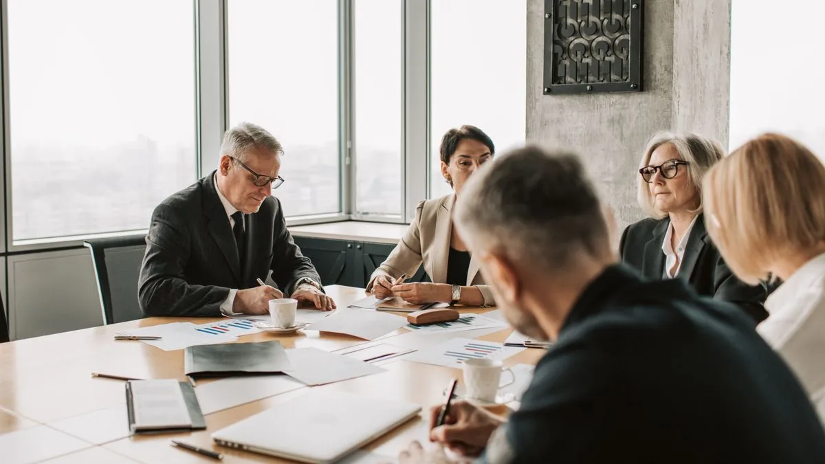 Business professionals engaged in a collaborative meeting around a conference table.