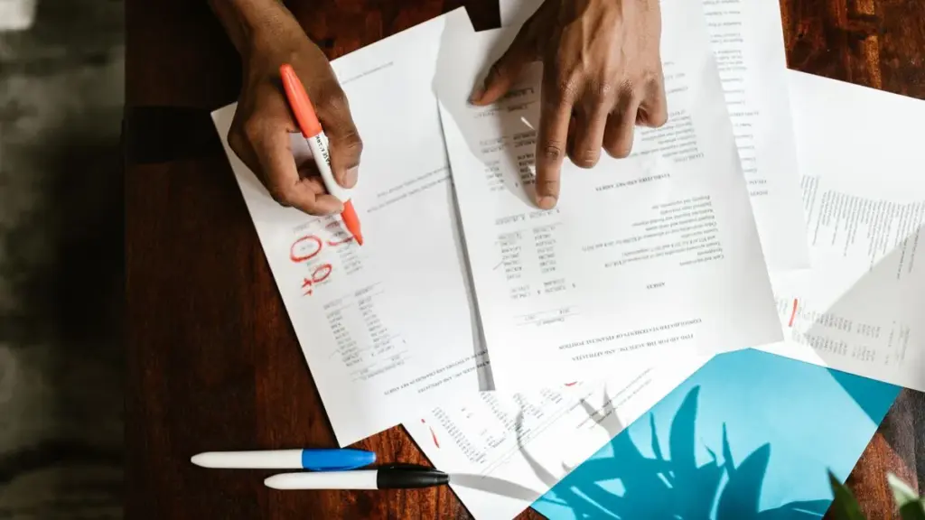 Overhead view of hands highlighting documents on a desk