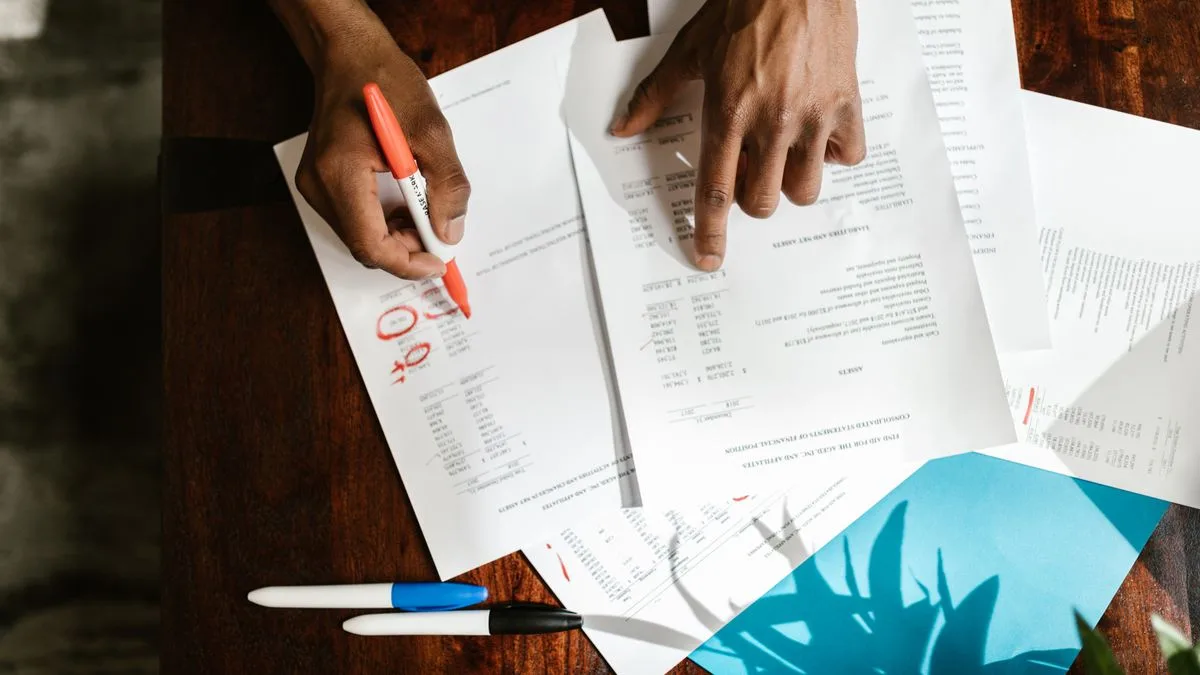 Overhead view of hands highlighting documents on a desk