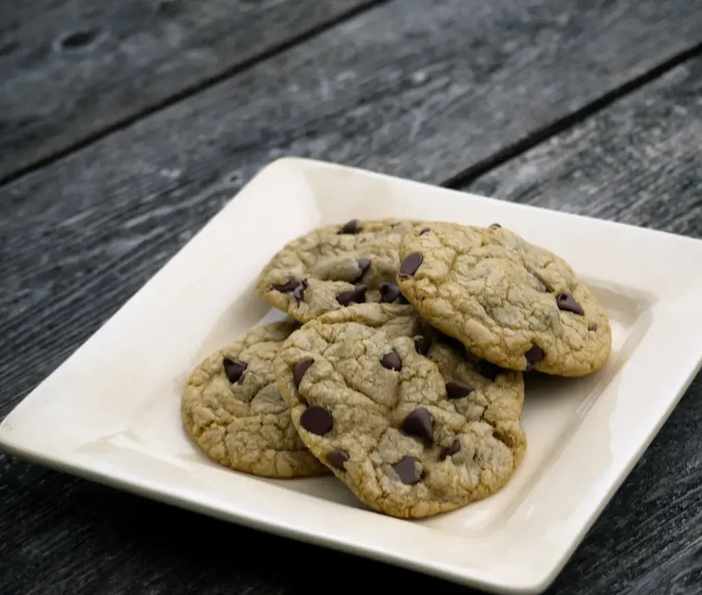 A plate of chocolate chip cookies on a wooden table