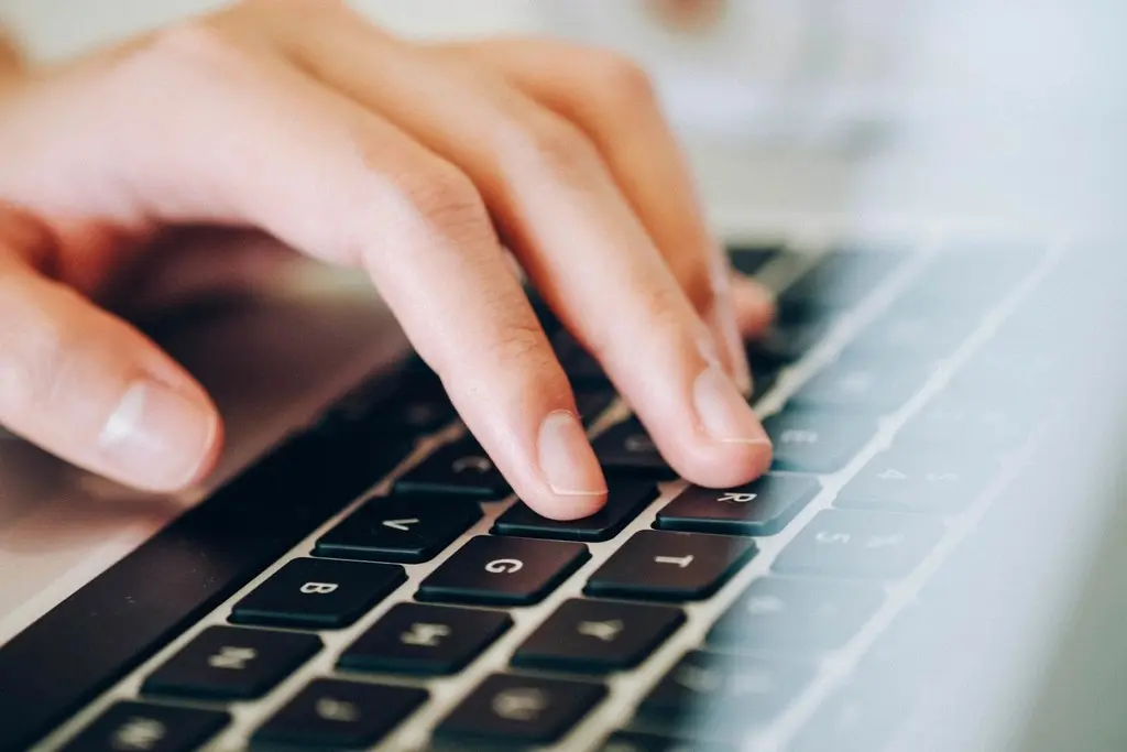 Close-up of a hand typing on a laptop keyboard, illustrating a keyboard-only accessibility test